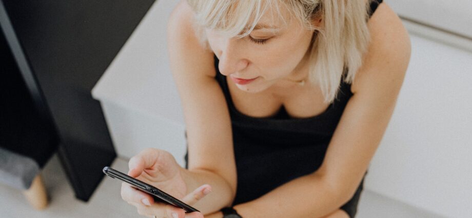 Woman sitting on the steps playing on her phone