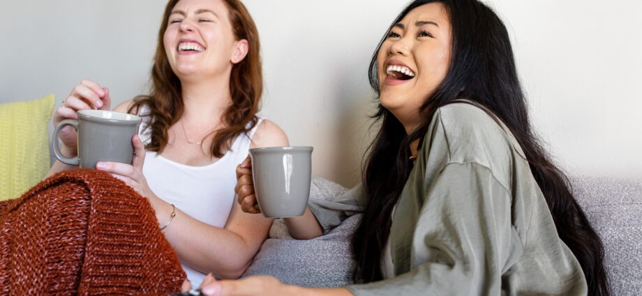 Roommates laughing out loud on the sofa