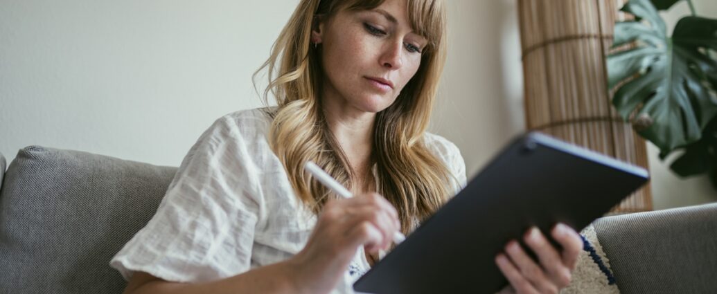 Woman using a stylus writing on a digital tablet